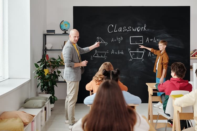 traditional classroom with a teacher, students and blackboard