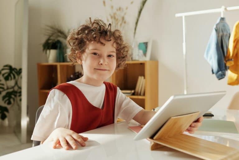 A smiling kid with a tablet