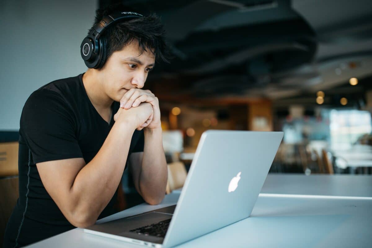 A man wearing headphones looking at laptop
