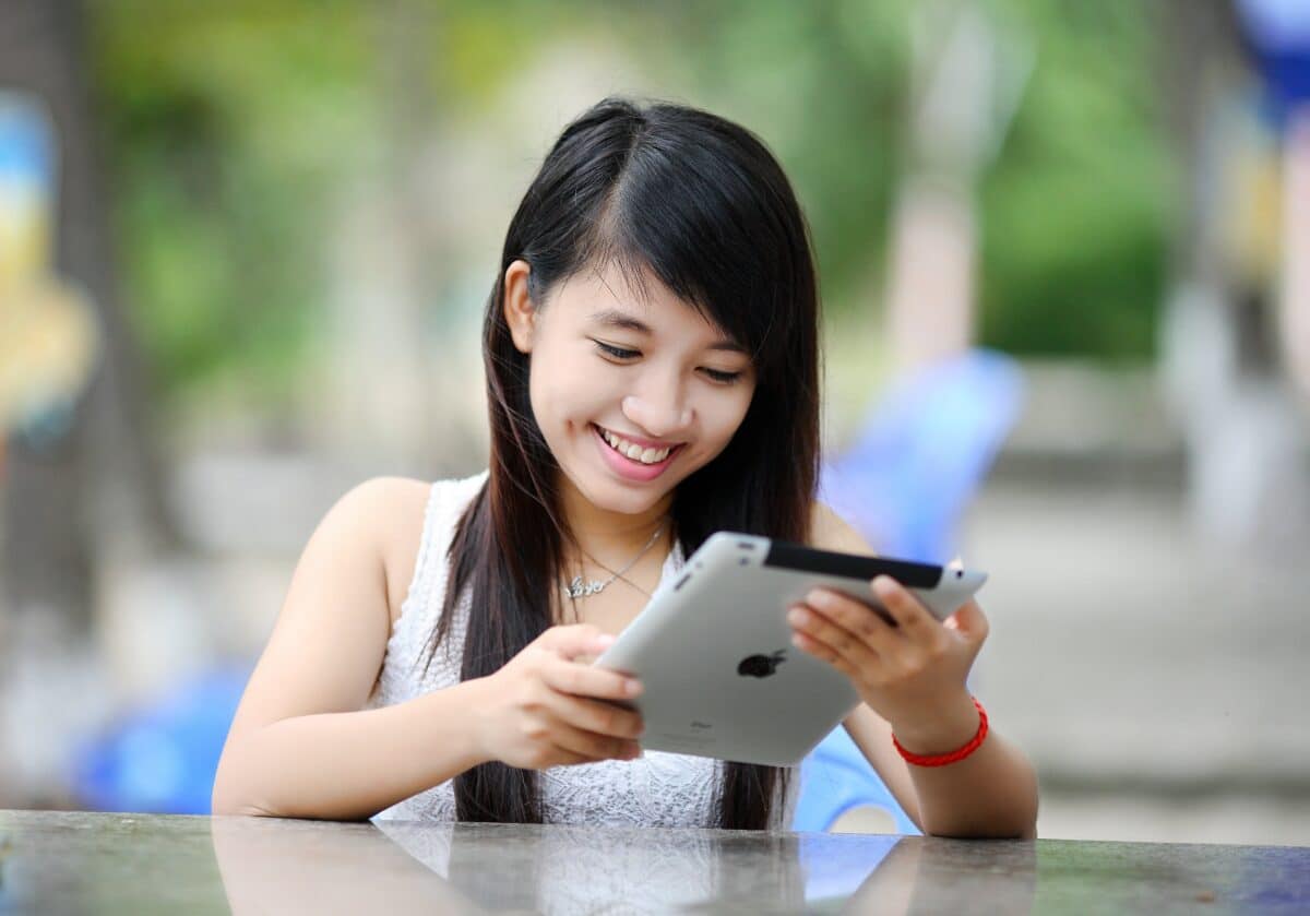 A girl smiling while  holding tablet